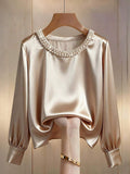 Blusa con decoración de perlas en el cuello