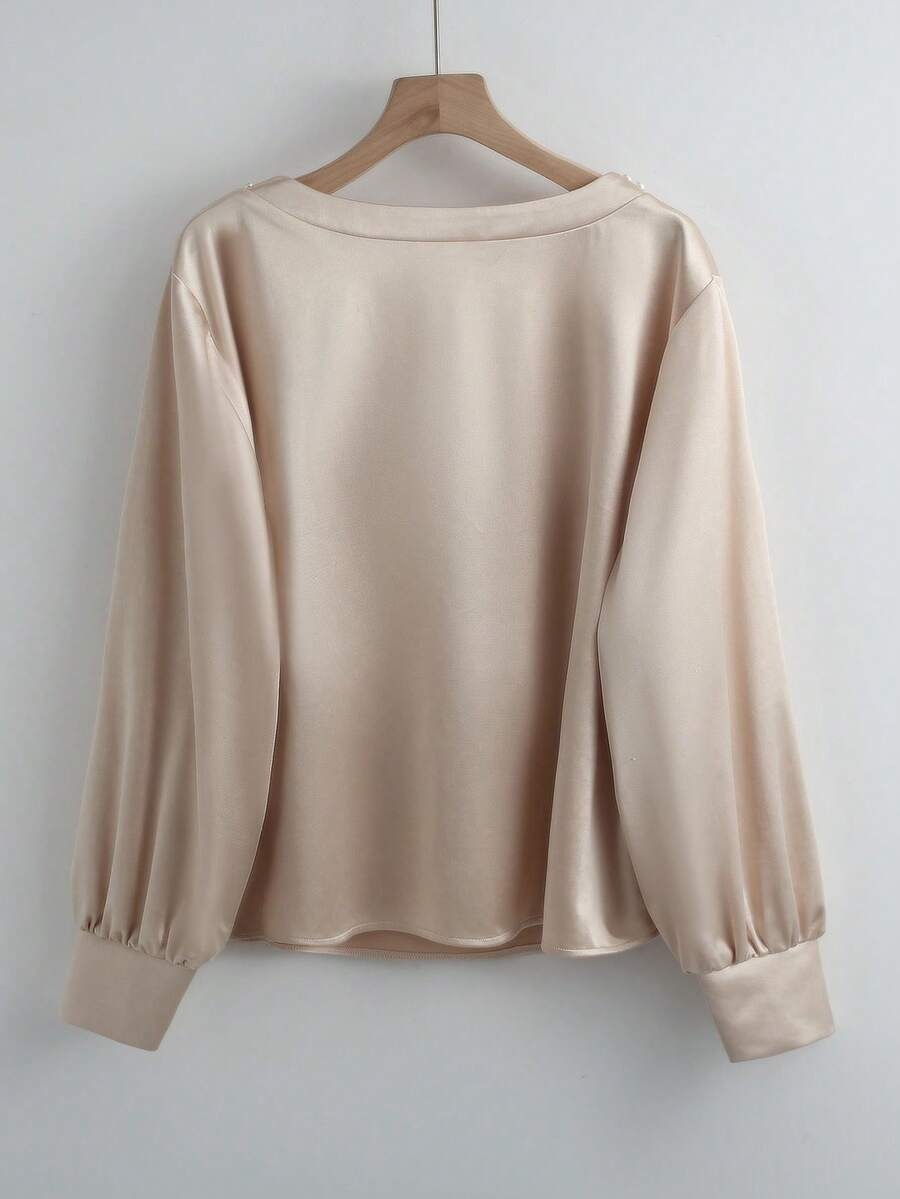 Blusa con decoración de perlas en el cuello