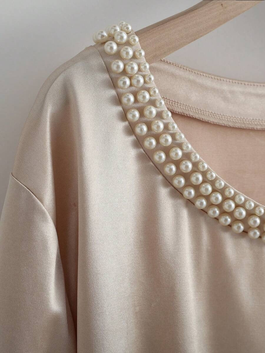 Blusa con decoración de perlas en el cuello